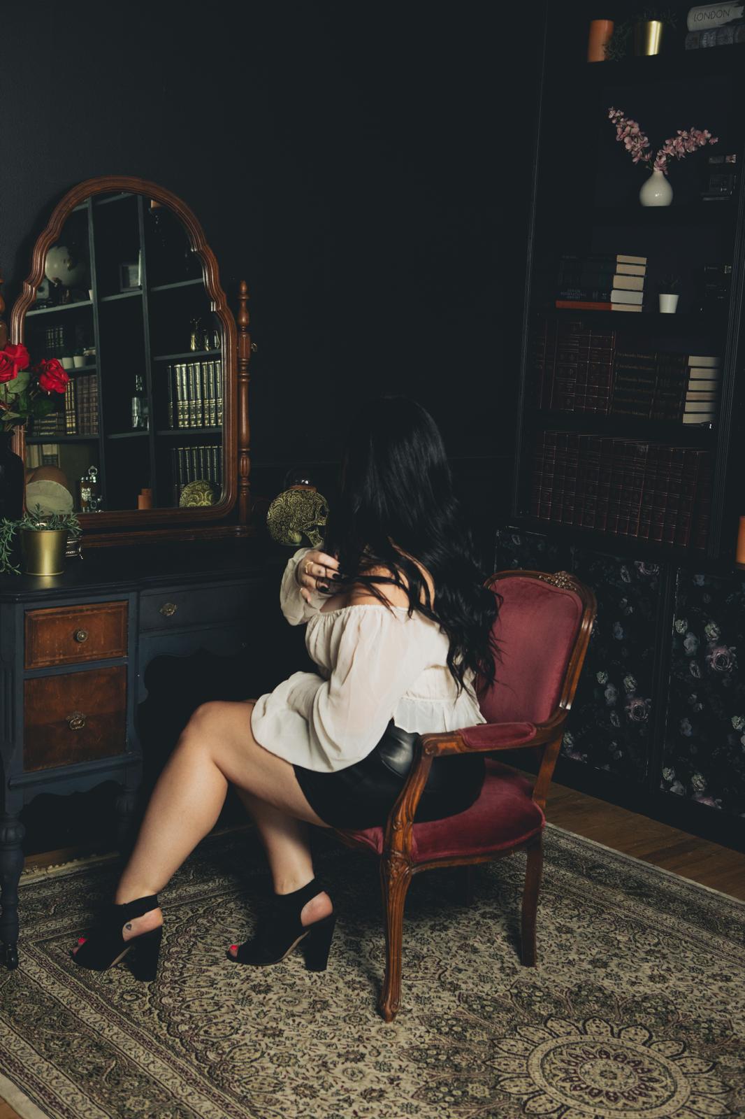 author seen from behind sitting at a vintage desk with mirror